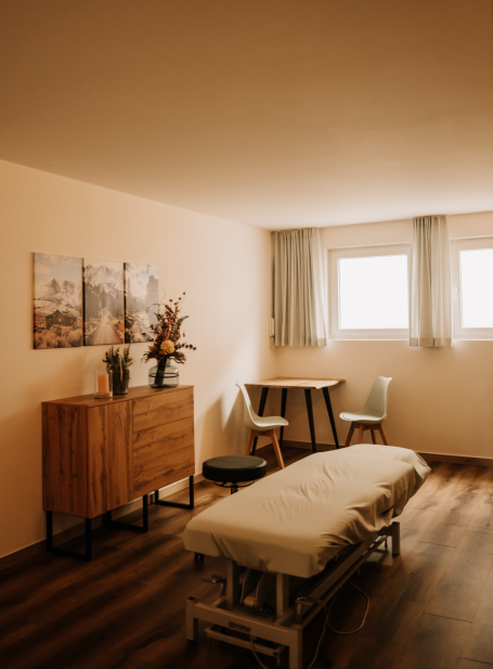 Behandlungsraum mit Therapieliege und warmer Lichtstimmung