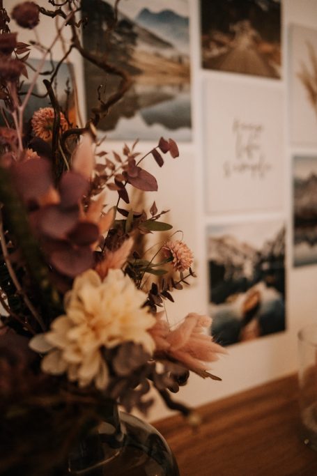 Wandbilder und Blumenarrangement im Wartebereich der Physiotherapiepraxis